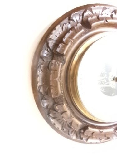 A circular Edwardian aneroid barometer set within a hand-carved mahogany frame with a brass bezel and visible mechanical movement. View V