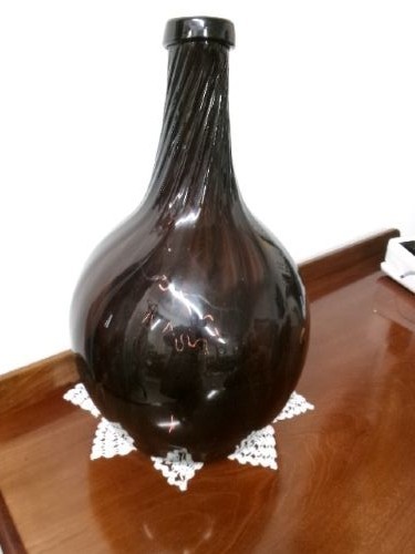 A deep amethyst hand-blown glass bottle featuring a bulbous onion-shaped body, a spiral-ribbed tapering neck, and an applied string lip rim.