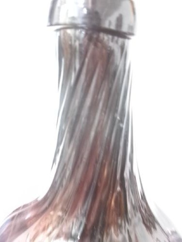 A deep amethyst hand-blown glass bottle featuring a bulbous onion-shaped body, a spiral-ribbed tapering neck, and an applied string lip rim. View II