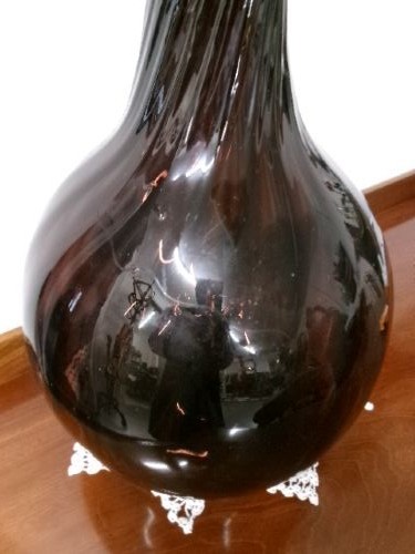 A deep amethyst hand-blown glass bottle featuring a bulbous onion-shaped body, a spiral-ribbed tapering neck, and an applied string lip rim. View VI
