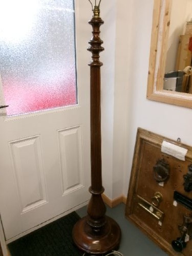 A dark turned mahogany standard lamp with a fluted central column and a moulded circular base.