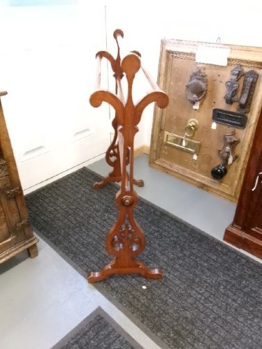 A freestanding Victorian mahogany towel rail featuring carved scrollwork supports and multiple horizontal rails on trestle feet. View II