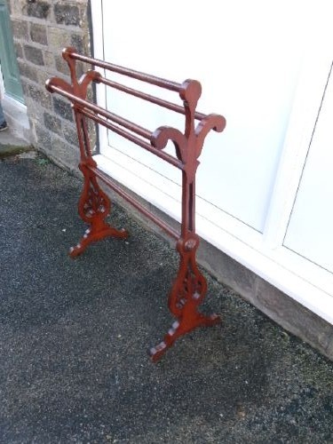 A freestanding Victorian mahogany towel rail featuring carved scrollwork supports and multiple horizontal rails on trestle feet. View VII