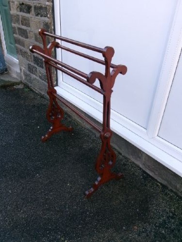 A freestanding Victorian mahogany towel rail featuring carved scrollwork supports and multiple horizontal rails on trestle feet. View VI