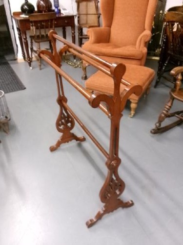 A freestanding Victorian mahogany towel rail featuring carved scrollwork supports and multiple horizontal rails on trestle feet. View VIII