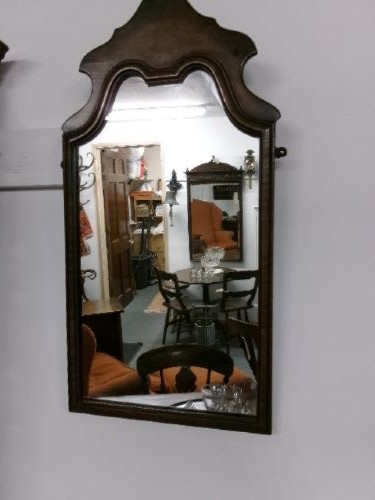 An antique walnut wall mirror with an arched, shaped top cresting and moulded frame. View II