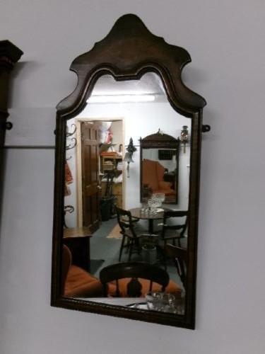 An antique walnut wall mirror with an arched, shaped top cresting and moulded frame. View III
