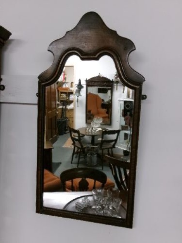 An antique walnut wall mirror with an arched, shaped top cresting and moulded frame. View IV