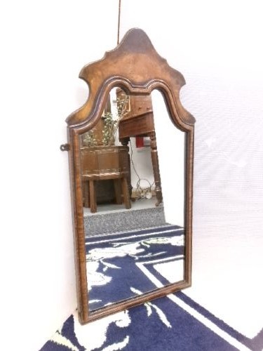 An antique walnut wall mirror with an arched, shaped top cresting and moulded frame. View X