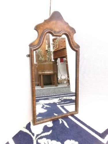 An antique walnut wall mirror with an arched, shaped top cresting and moulded frame. View IX