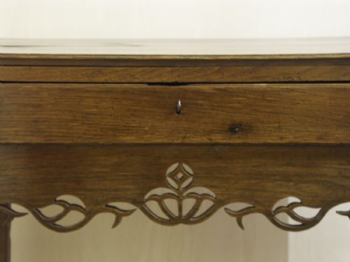 fig 1. An eighteenth-century Welsh oak side table featuring a single drawer and an intricate fretted apron supported by four square legs.
