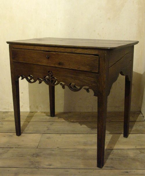 fig 2. An eighteenth-century Welsh oak side table featuring a single drawer and an intricate fretted apron supported by four square legs.