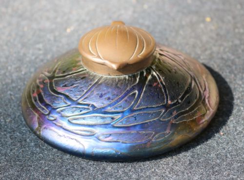 fig 1. A low domed Art Nouveau iridescent blue glass inkwell with raised veined patterns and a hinged brass lid.