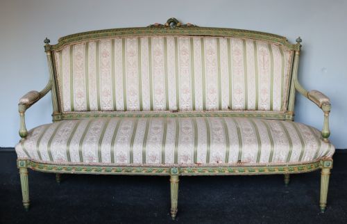 fig 1. A French Empire style carved wooden settee featuring a green painted frame with fluted legs and striped woven fabric upholstery.