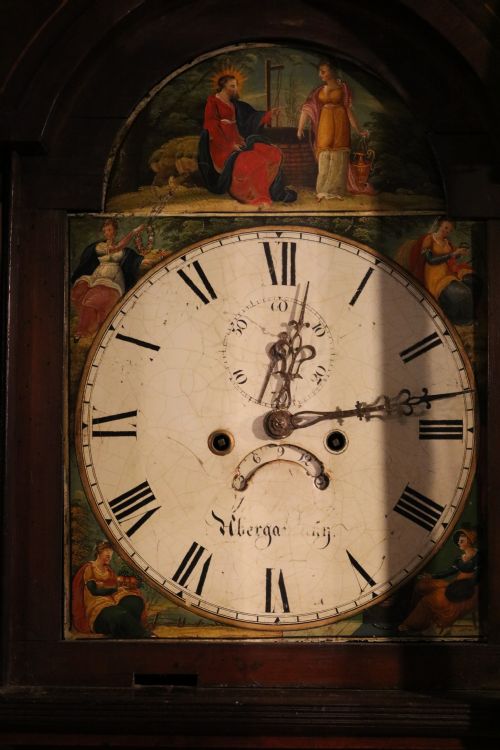 fig 1. A tall 19th-century Welsh mahogany longcase clock featuring a swan-neck pediment hood, painted arch dial with Roman numerals, and flame mahogany trunk door.