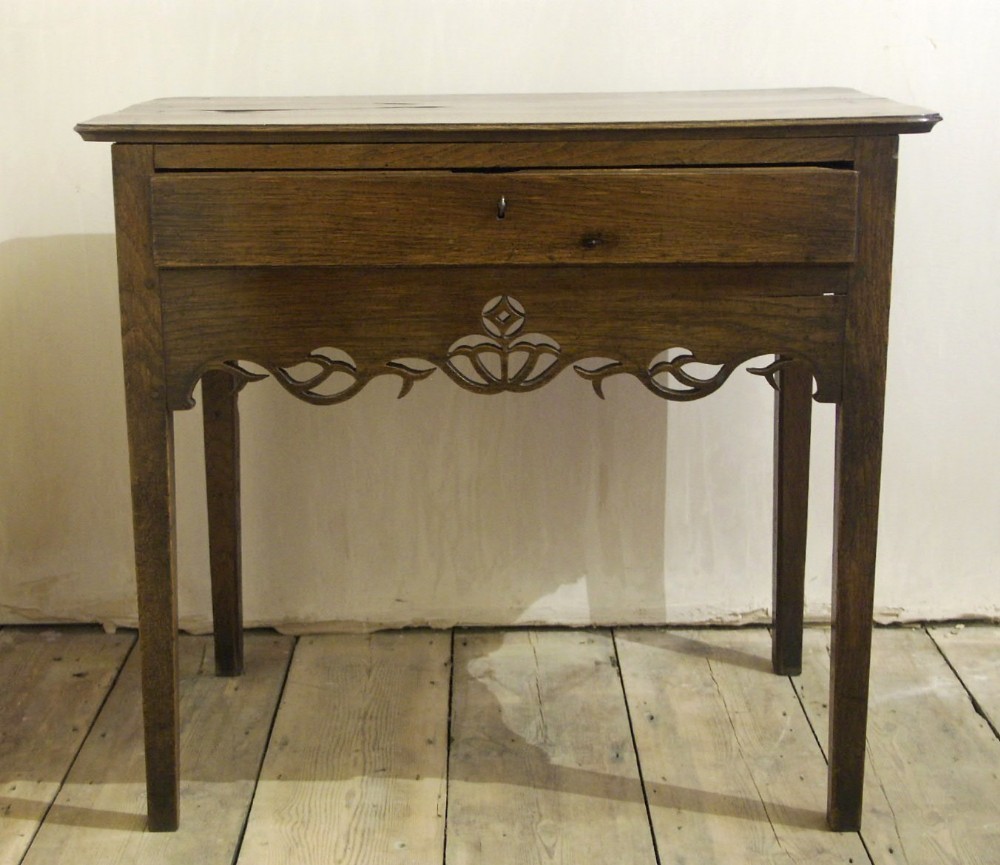 An eighteenth-century Welsh oak side table featuring a single drawer and an intricate fretted apron supported by four square legs.