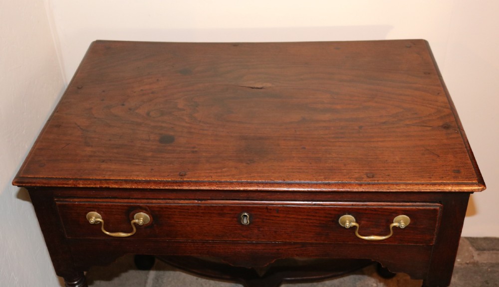 An 18th-century dark oak side table featuring a single drawer with brass drop handles, a shaped apron, turned legs, and an X-frame stretcher. View VIII