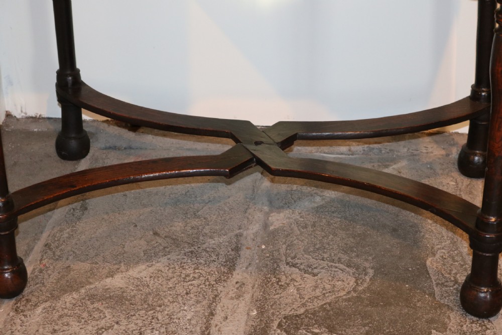 An 18th-century dark oak side table featuring a single drawer with brass drop handles, a shaped apron, turned legs, and an X-frame stretcher. View X