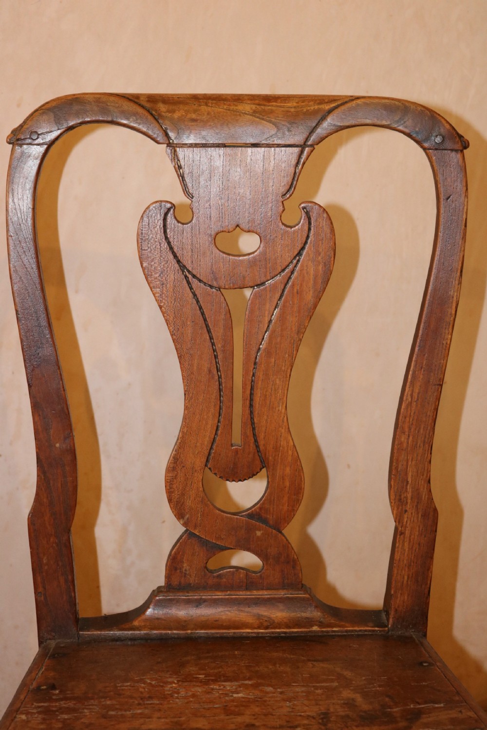 A set of three 18th-century Welsh elm side chairs featuring shaped splat backs, solid wooden seats, and square legs with stretchers. View V