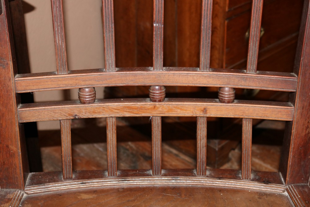 A late 18th-century Welsh dark oak armchair featuring a vertical slat back, turned arm supports, a solid wooden seat, and a square stretcher frame. View IV