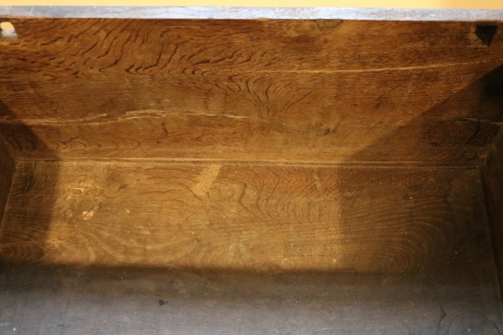 A small 17th-century Welsh dark oak coffer bach featuring a hinged top, single lower drawer with brass ring handles, and turned bun feet. View IX