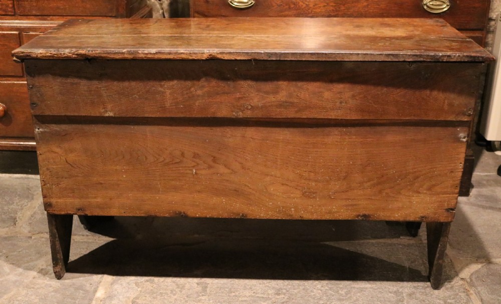 A seventeenth-century dark oak coffer featuring three carved front panels with geometric diamond lozenge motifs and a brass keyhole escutcheon. View VIII