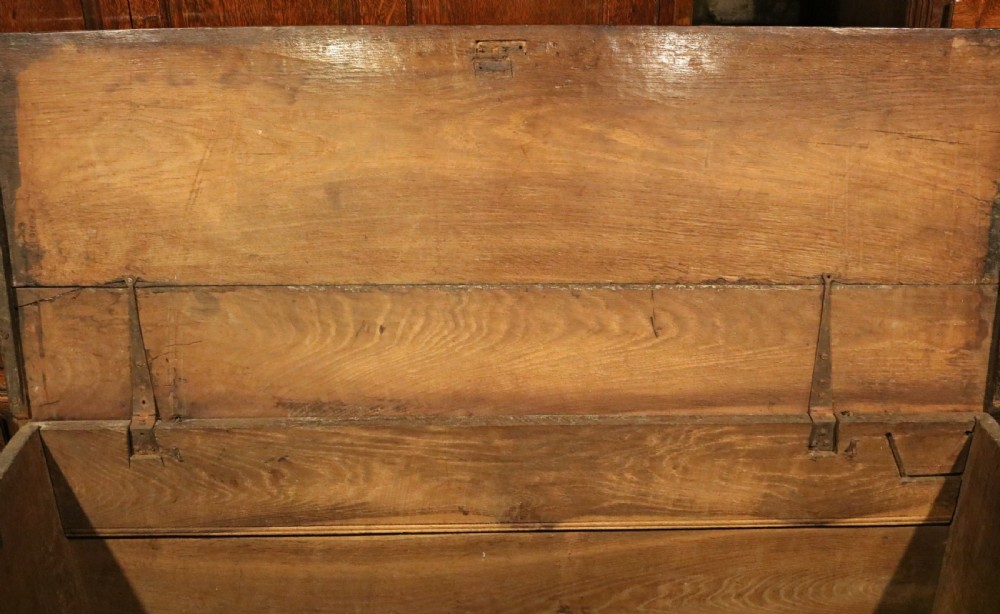 A seventeenth-century dark oak coffer featuring three carved front panels with geometric diamond lozenge motifs and a brass keyhole escutcheon. View IX