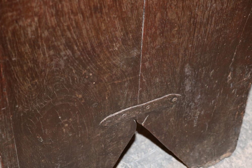 A seventeenth-century dark oak coffer featuring three carved front panels with geometric diamond lozenge motifs and a brass keyhole escutcheon. View XI
