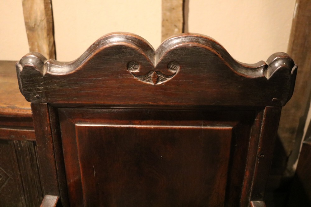 A 17th-century Welsh oak armchair featuring a central yew-wood back panel, down-swept armrests, turned front legs, and a carved crest rail. View VI