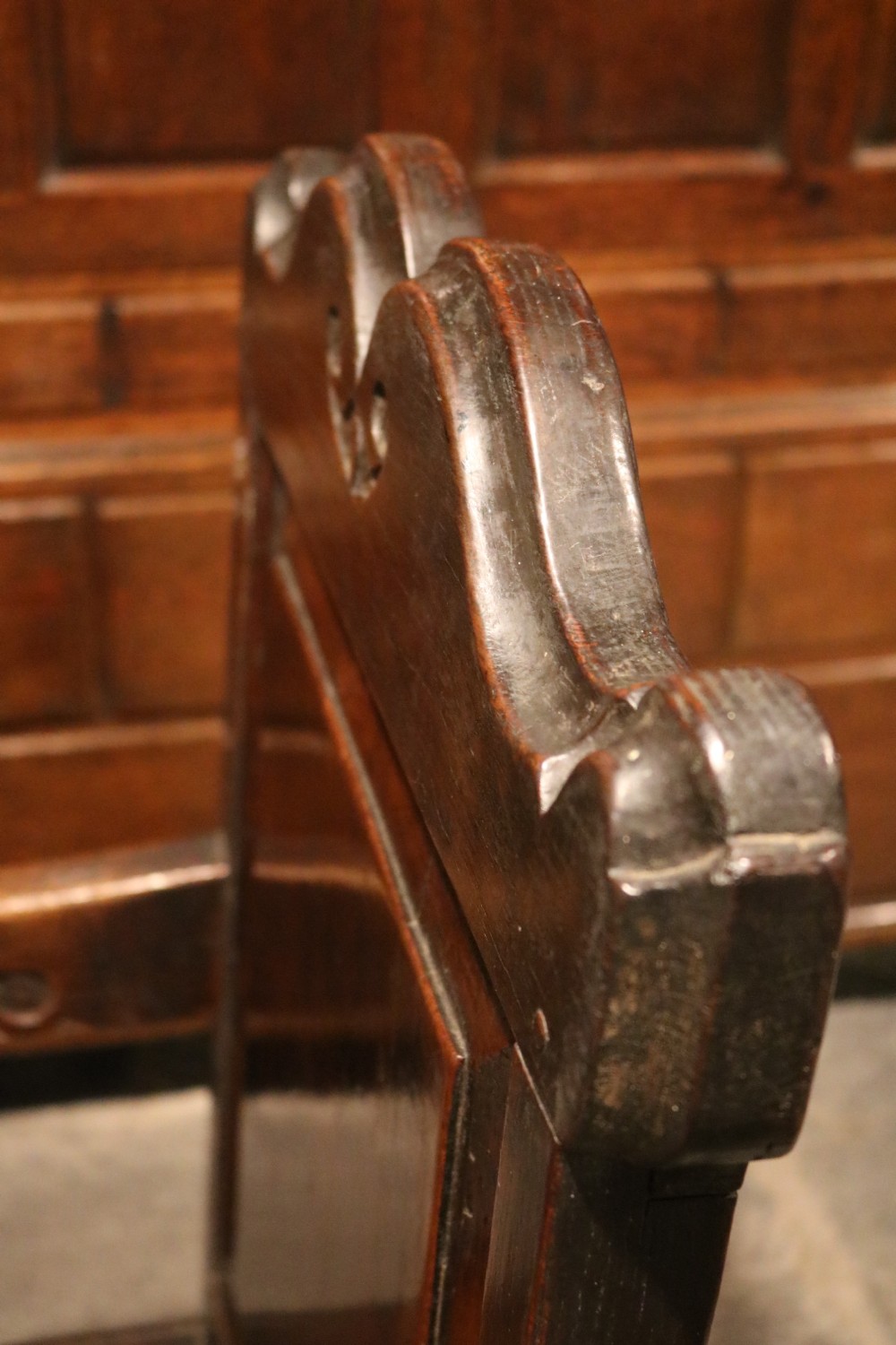A 17th-century Welsh oak armchair featuring a central yew-wood back panel, down-swept armrests, turned front legs, and a carved crest rail. View VII