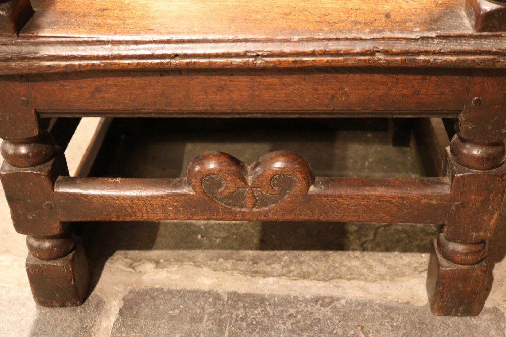 A 17th-century Welsh oak armchair featuring a central yew-wood back panel, down-swept armrests, turned front legs, and a carved crest rail. View VIII