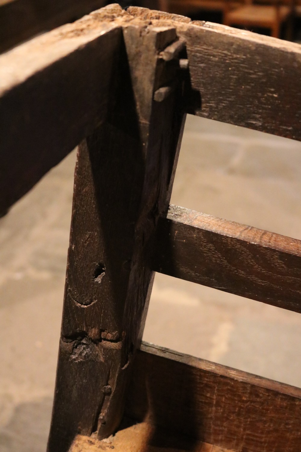 A 17th-century Welsh oak armchair featuring a central yew-wood back panel, down-swept armrests, turned front legs, and a carved crest rail. View XII