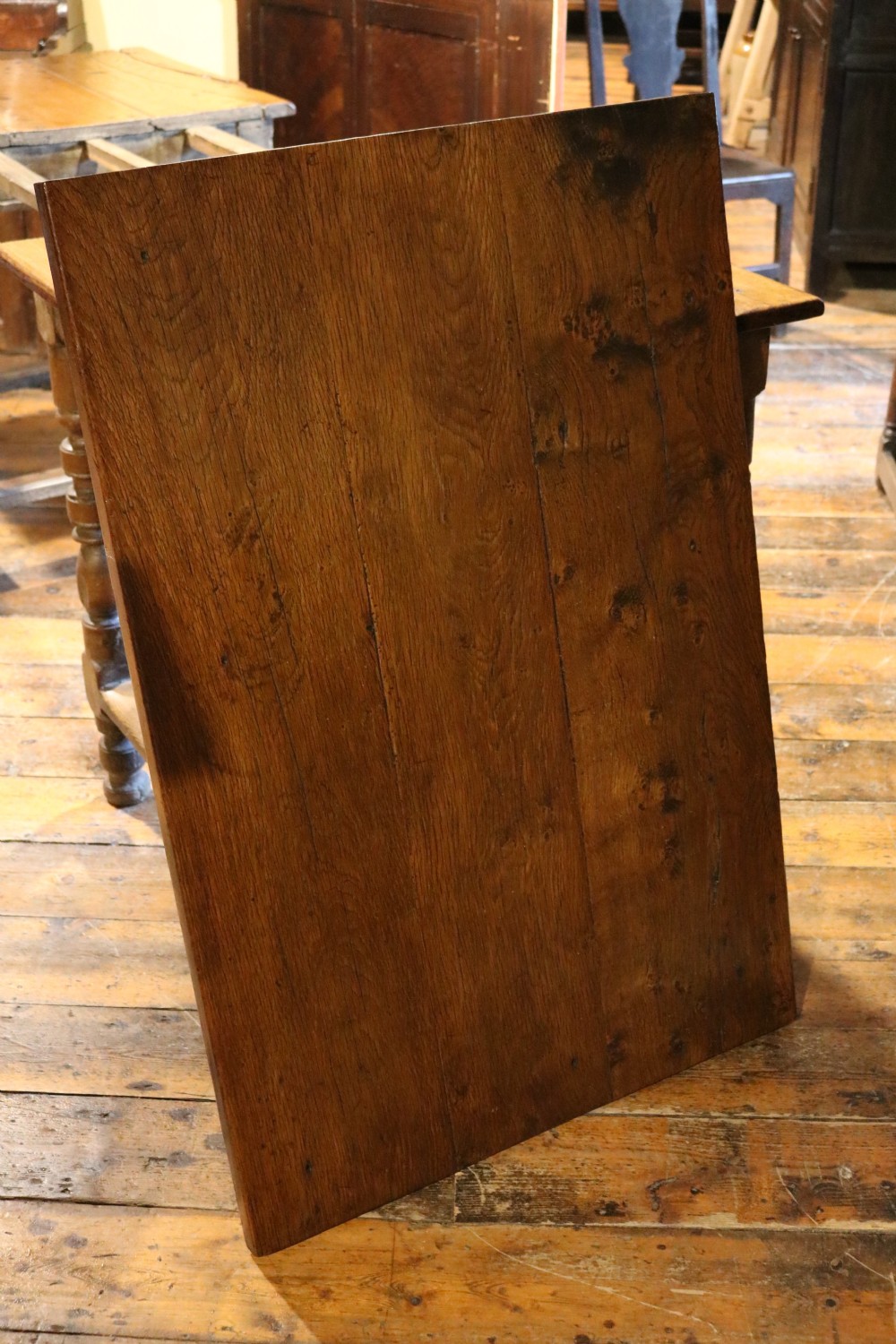 A long Basque chestnut extending dining table with a plank top, turned legs, and perimeter stretchers. View XI