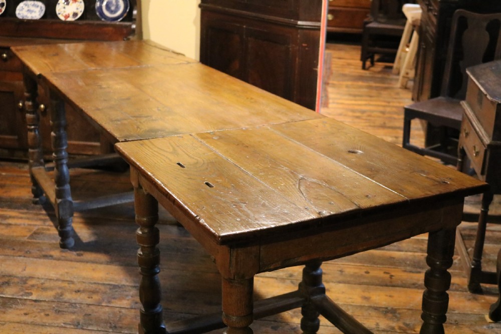 A long Basque chestnut extending dining table with a plank top, turned legs, and perimeter stretchers. View XII