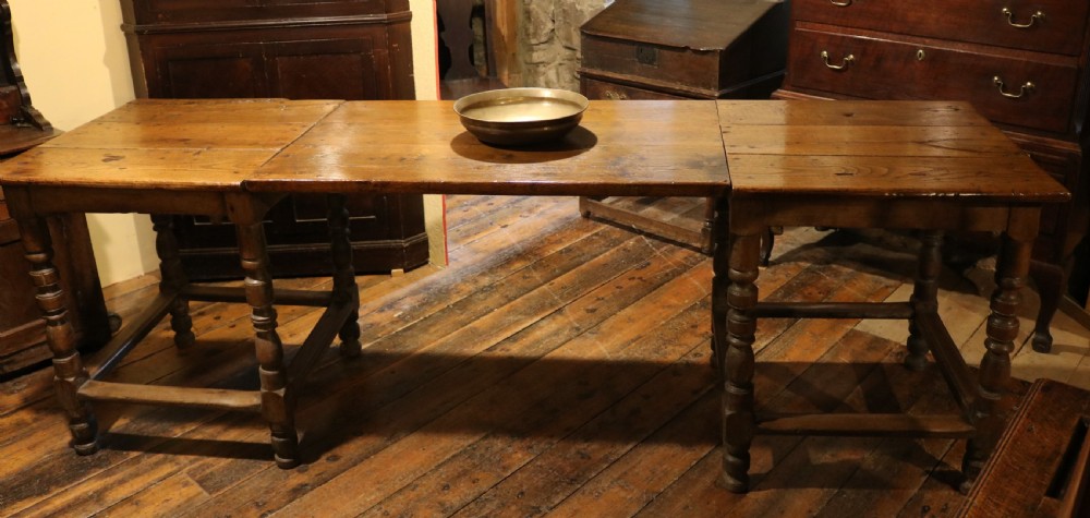 A long Basque chestnut extending dining table with a plank top, turned legs, and perimeter stretchers. View XIV