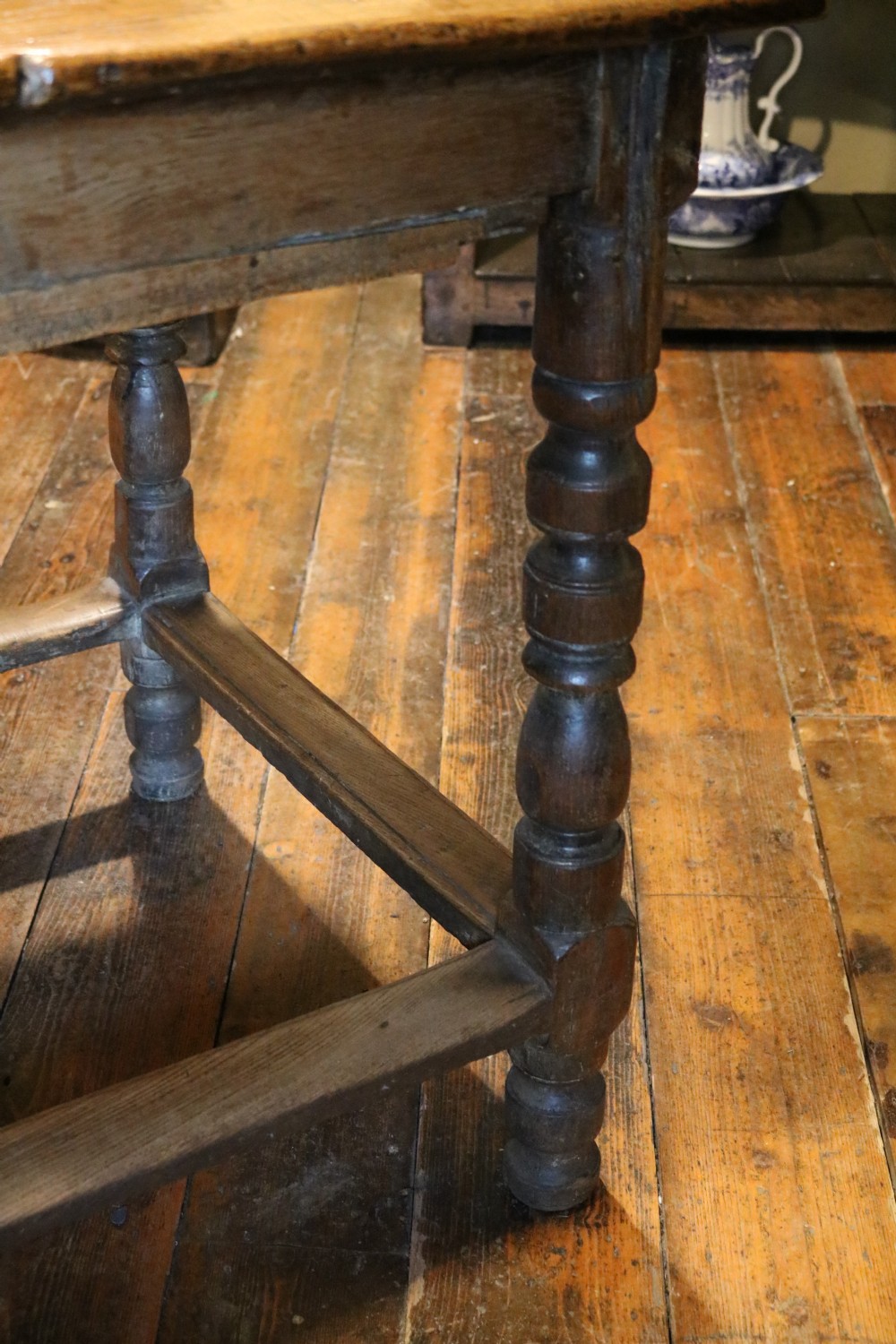 A long Basque chestnut extending dining table with a plank top, turned legs, and perimeter stretchers. View XV