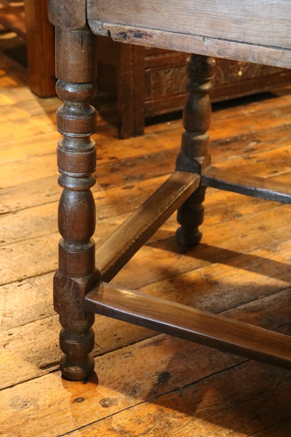 A long Basque chestnut extending dining table with a plank top, turned legs, and perimeter stretchers. View XVI