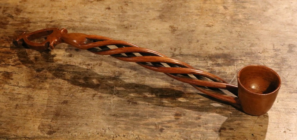 An early nineteenth-century carved Welsh fruitwood lovespoon featuring an openwork spiral stem and a deep bowl.