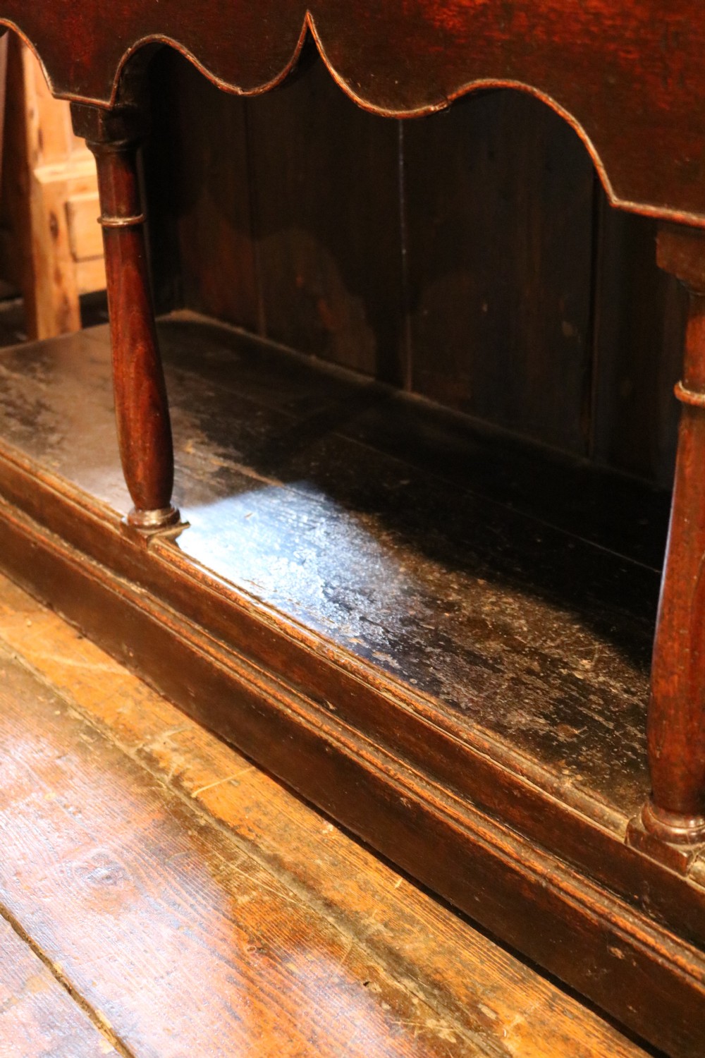 An 18th-century dark oak Welsh dresser featuring an upper plate rack, three brass-handled drawers over a scalloped apron, and a lower potboard shelf. View XIX