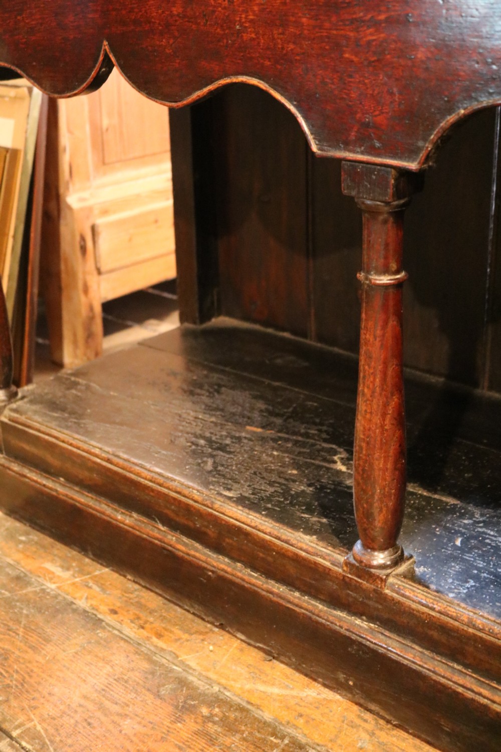An 18th-century dark oak Welsh dresser featuring an upper plate rack, three brass-handled drawers over a scalloped apron, and a lower potboard shelf. View XX