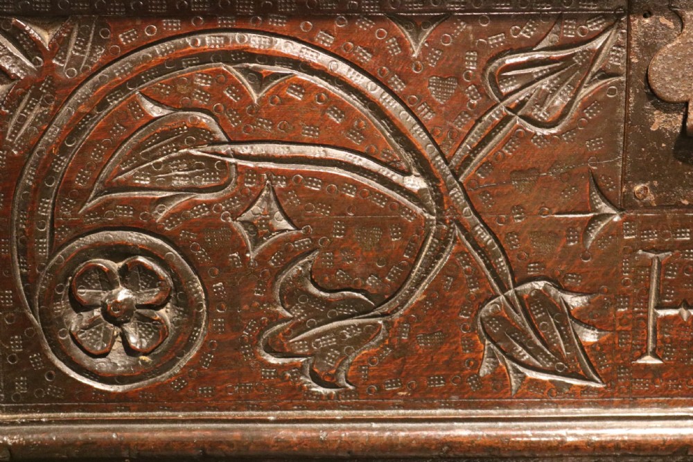 A 17th-century dark oak carved table box featuring scrollwork leaf motifs, carved initials HC, an iron lockplate, and a lower drawer. View IX