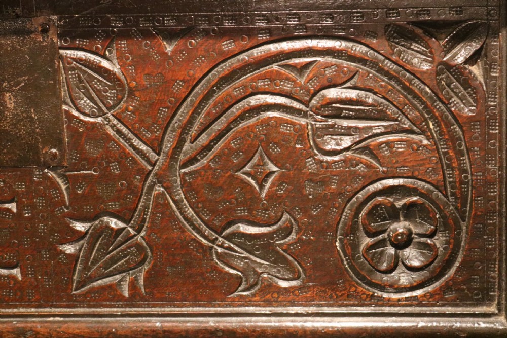 A 17th-century dark oak carved table box featuring scrollwork leaf motifs, carved initials HC, an iron lockplate, and a lower drawer. View X