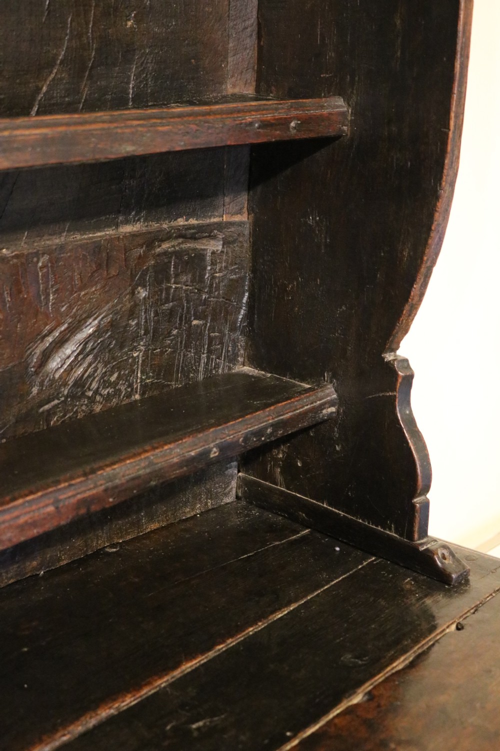 A dark oak Welsh cupboard dresser with a three-tiered upper display rack and a lower base containing two fielded panel doors. View XII