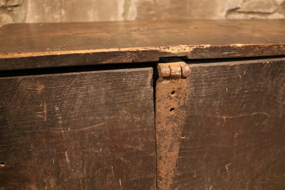 A dark brown 16th-century six-plank oak coffer featuring a rectangular top and V-cut end legs. View XV