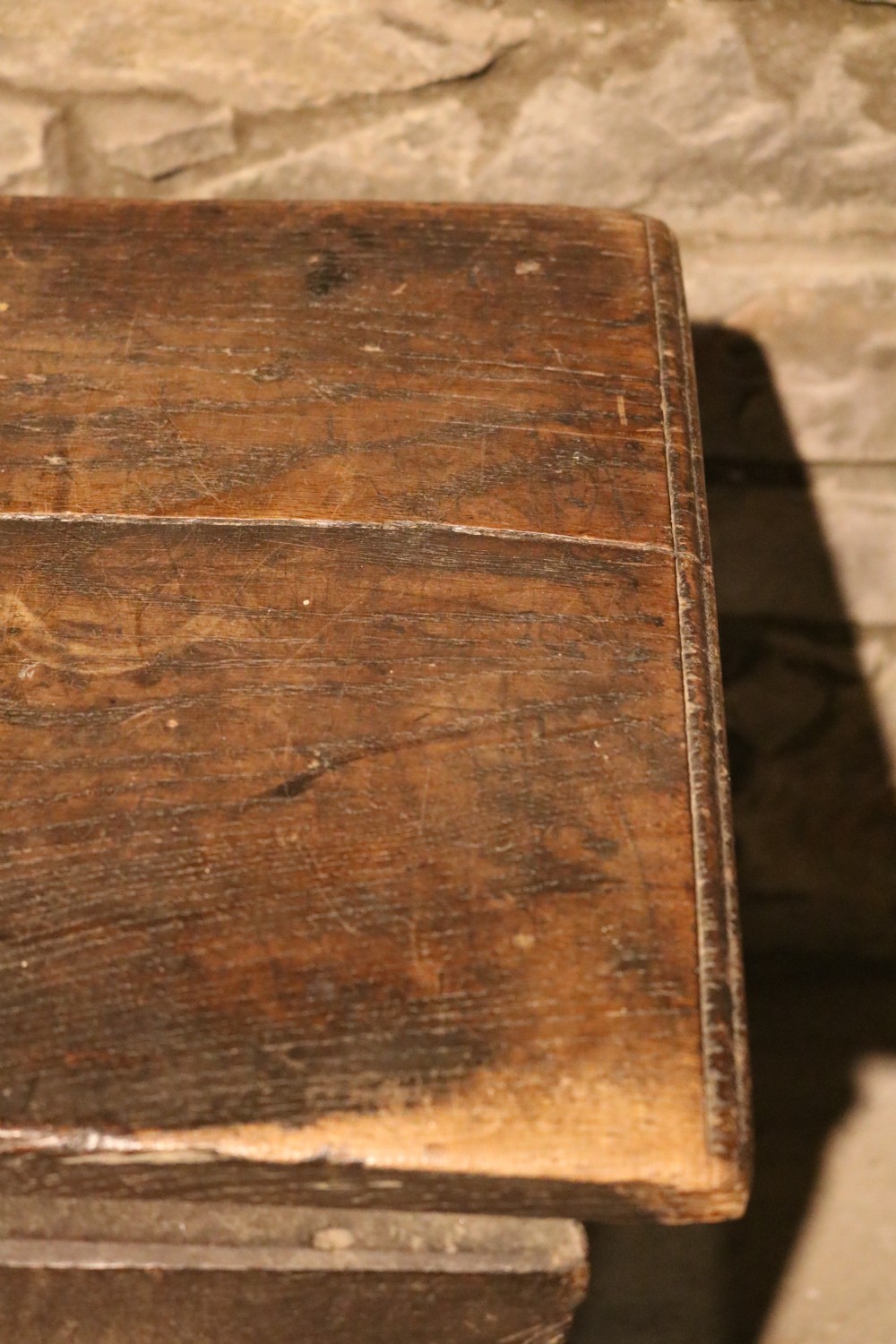 A dark brown 16th-century six-plank oak coffer featuring a rectangular top and V-cut end legs. View XVII