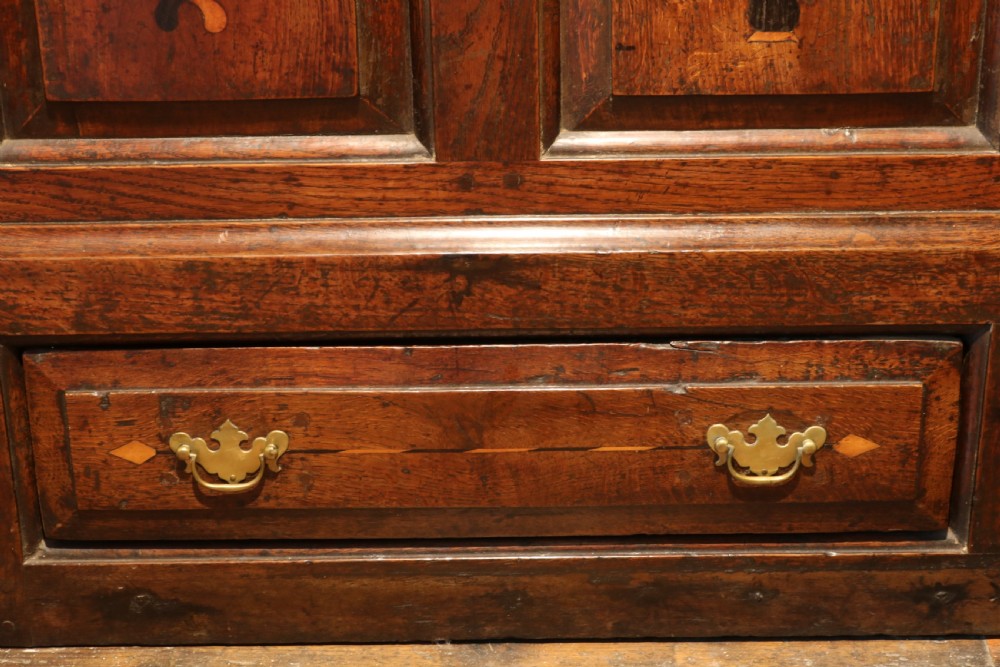 An 18th-century dark oak Welsh coffer featuring four arched inlaid panels above two drawers with brass handles. View VIII
