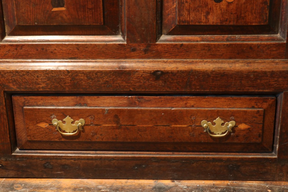 An 18th-century dark oak Welsh coffer featuring four arched inlaid panels above two drawers with brass handles. View IX