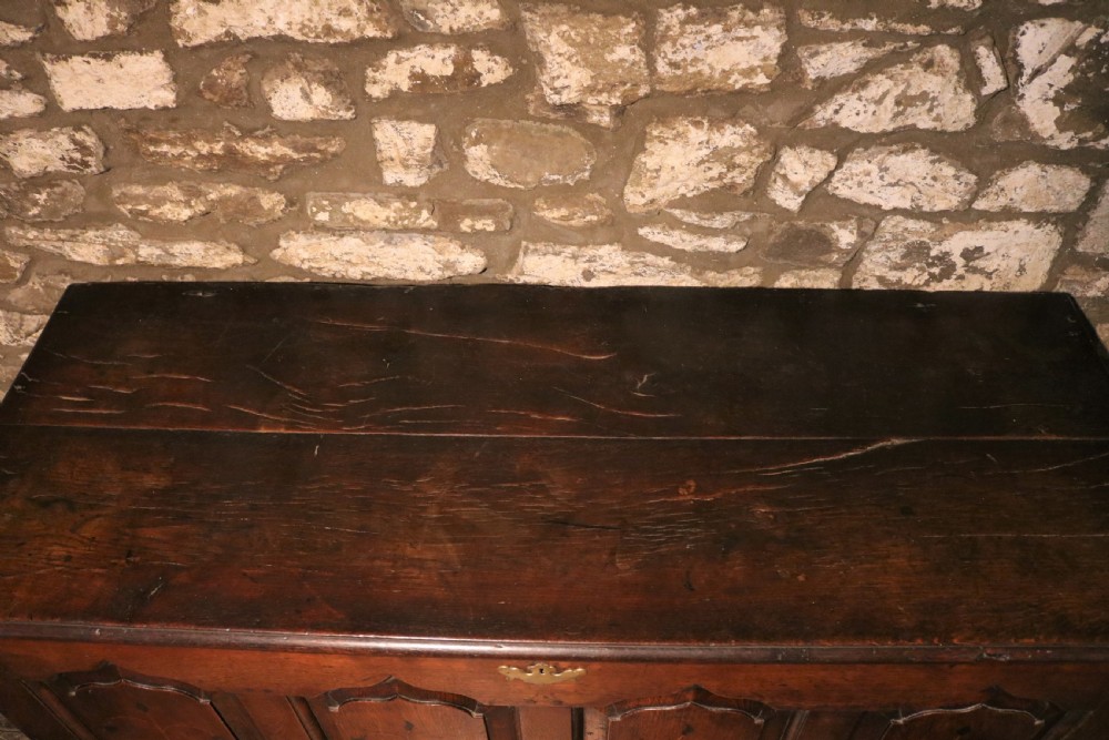 An 18th-century dark oak Welsh coffer featuring four arched inlaid panels above two drawers with brass handles. View XI