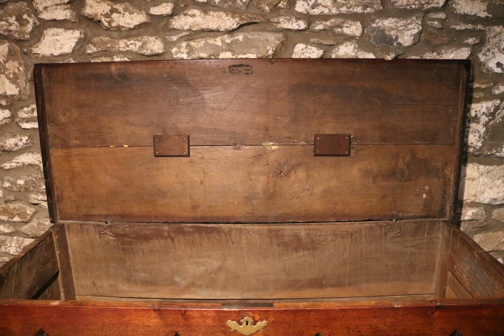An 18th-century dark oak Welsh coffer featuring four arched inlaid panels above two drawers with brass handles. View XII