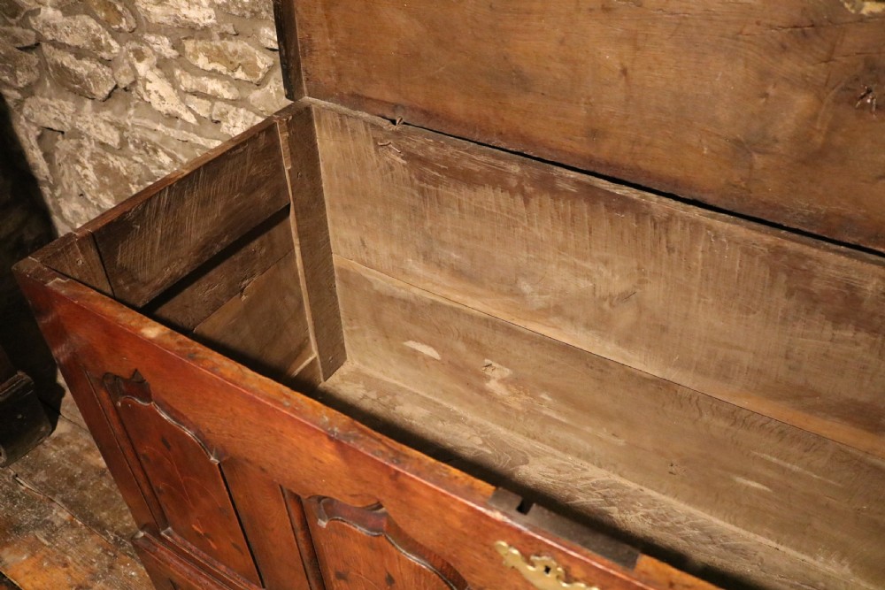 An 18th-century dark oak Welsh coffer featuring four arched inlaid panels above two drawers with brass handles. View XIV